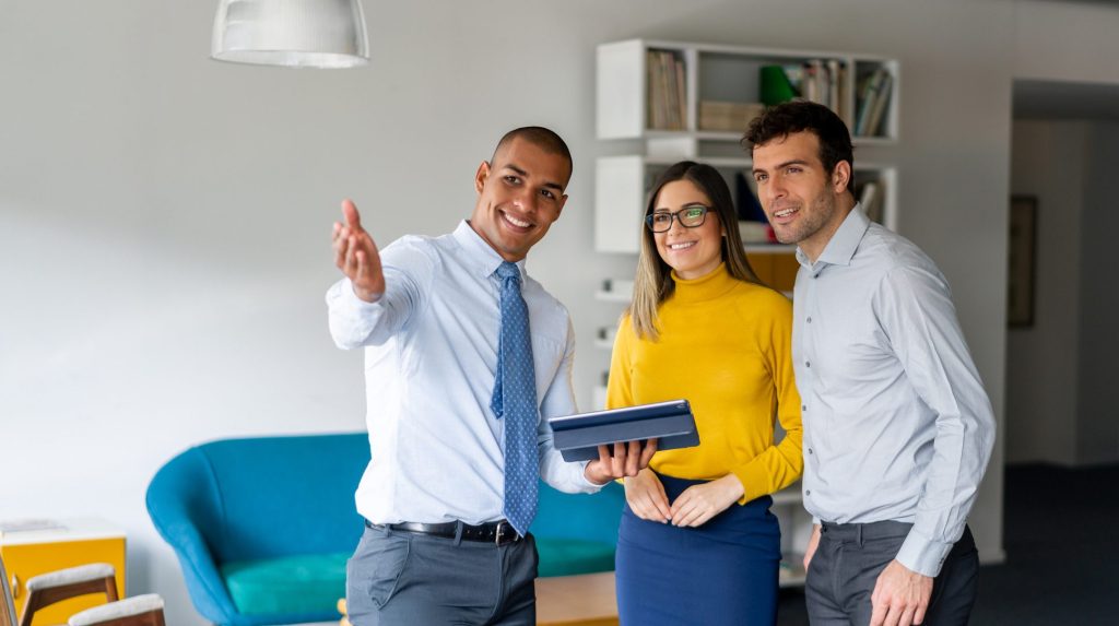 Realtor showing a property to a happy couple